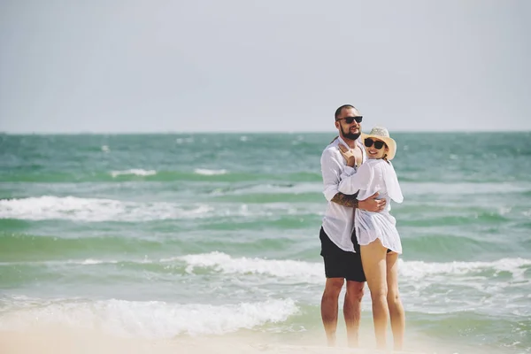 ビーチでバレンタインデーを過ごし 暖かい海の波を楽しむ幸せな若いカップル — ストック写真