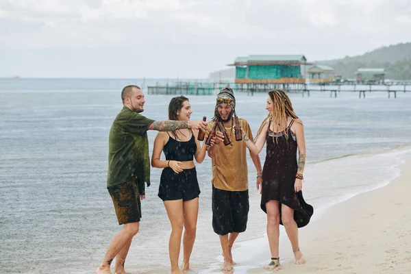 Grupa Przyjaciół Spędzających Czas Plaży Czasie Ulewnego Deszczu Wznoszących Toast — Zdjęcie stockowe