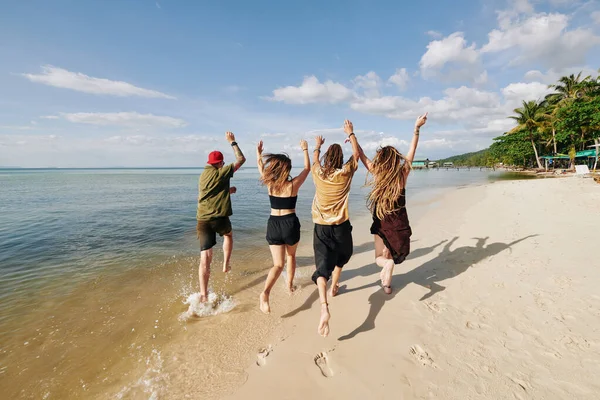 Kelompok Anak Muda Yang Bahagia Mengangkat Senjata Dan Berlari Pantai — Stok Foto