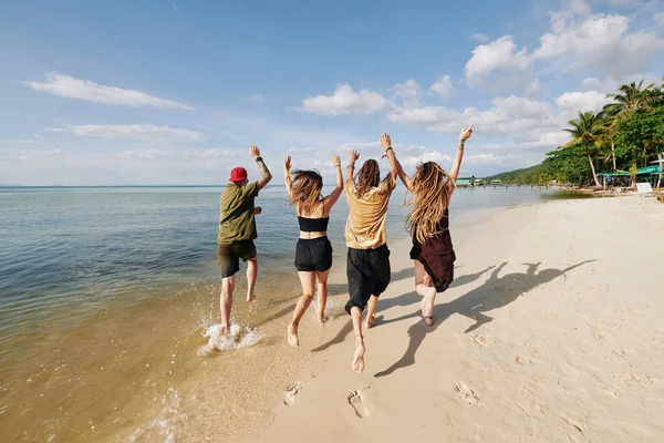 Grupo Jóvenes Felices Que Levantan Las Armas Corren Playa —  Fotos de Stock