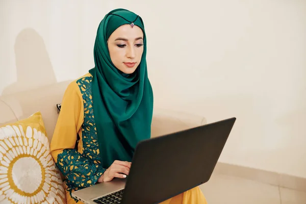 Красивая Мусульманская Молодая Женщина Традиционном Платье Хиджабе Сидит Диване Работает — стоковое фото