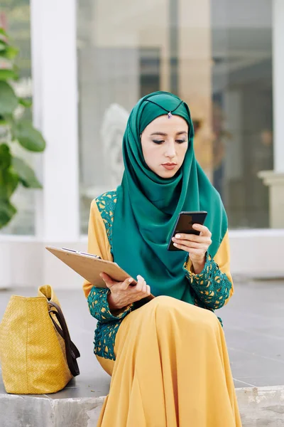 Vážná Mladá Muslimská Podnikatelka Tradičních Šatech Sedí Venku Kontroluje Textové — Stock fotografie