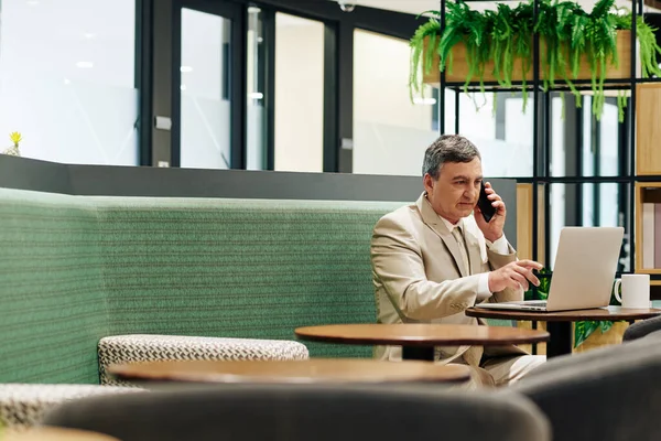 Medelålders Entreprenör Talar Telefon Med Assistent När Läser Dokument Bärbar — Stockfoto