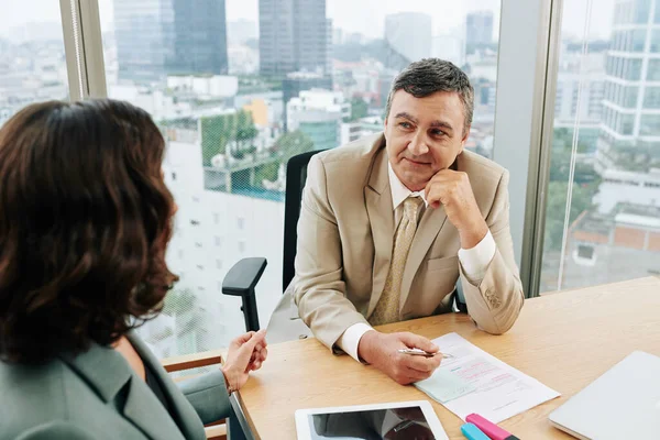 Sorridente Uomo Affari Maturo Ascoltando Relazione Del Collega Prendendo Appunti — Foto Stock