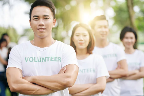 Портрет Усміхненого Впевненого Волонтера Голови Стоїть Складеними Руками Його Команда — стокове фото