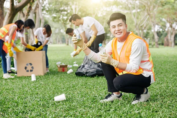 Alegre Jovem Voluntário Vietnamita Mostrando Lata Garrafa Plástico Que Ele — Fotografia de Stock