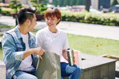 Pozitif genç Vietnamlı çift alışveriş merkezinde yaptıkları alışverişleri kontrol ediyor.