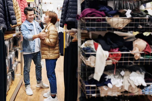 Vrolijke Jongeman Helpen Vriendin Ritsen Winter Jas Proberen Winkel — Stockfoto