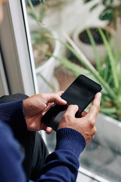 Händerna Person Som Står Vid Fönstret Och Skicka Textmeddelanden Eller — Stockfoto