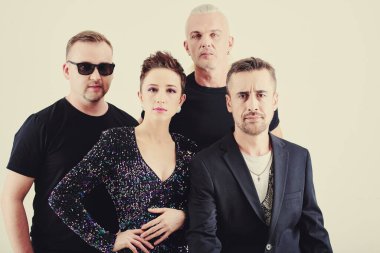 Müzik grubu üyeleri performanstan önce konser kıyafetleri içinde poz veriyorlar.