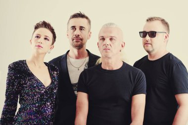 Müzik grubu üyeleri konser posterinden bilgi okuyor