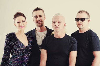 Pozitif yetenekli yaratıcı müzik grubu konser kıyafetleri içinde poster için poz veriyor.