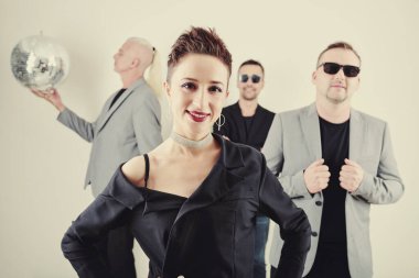 Çekici genç bir kadın konserde ya da etkinlikte grubuyla sahneye çıkmaya hazır.