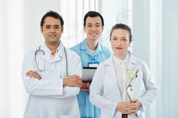 带着平板电脑 剪贴板和听诊器站在镜头前开心而自信的医护人员的画像 — 图库照片