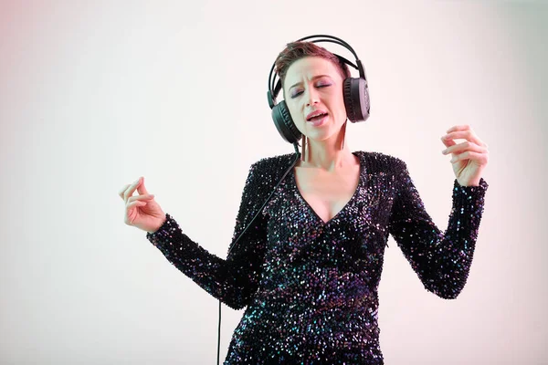 Parlak Parti Elbisesi Içinde Güzel Bir Kadın Şarkıcı Kulaklıkla Şarkı — Stok fotoğraf