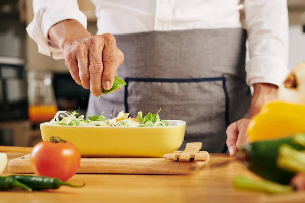 Man Knijpt Helft Van Verse Limoen Een Kom Salade Tafel — Stockfoto