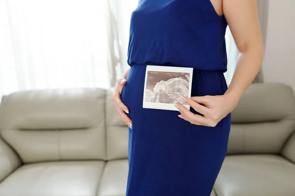 穿着深蓝色晚礼服的孕妇 对她的孩子进行超声波成像 — 图库照片