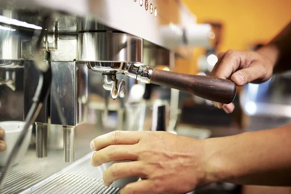 お客様のための飲料を醸造する際にコーヒーマシンにタンパーを入れてバリスタのクローズアップイメージ — ストック写真