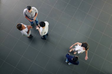 Ofiste iş adamları konuşuyor, projeleri ve fikirleri tartışıyor, yukarıdan bakıyorlar.