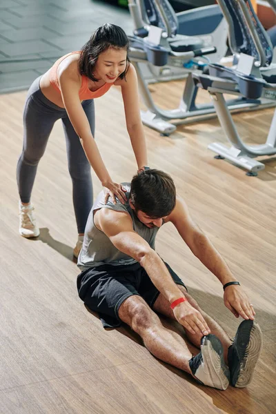 Smiling Female Fitness Trainer Pushing Back Her Client Reaching His — Stock Photo, Image