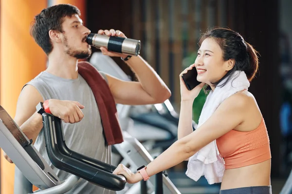 Cheerful Young Vietnamese Woman Talking Phone Riding Stationary Bike Her — Stock Photo, Image