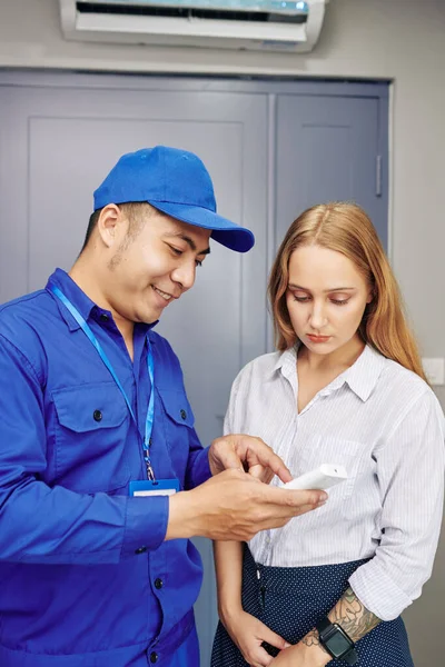 Técnico Uniforme Explicando Jovem Mulher Como Usar Condicionado Controle Remoto — Fotografia de Stock