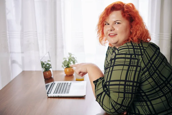 Sırıtan Kızıl Saçlı Şişman Kadının Portresi Masasındaki Açık Dizüstü Bilgisayarı — Stok fotoğraf