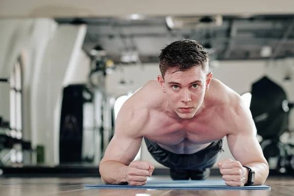 Entschlossener Hemdloser Junger Mann Steht Plankenstellung Auf Yogamatte Lokaler Turnhalle — Stockfoto