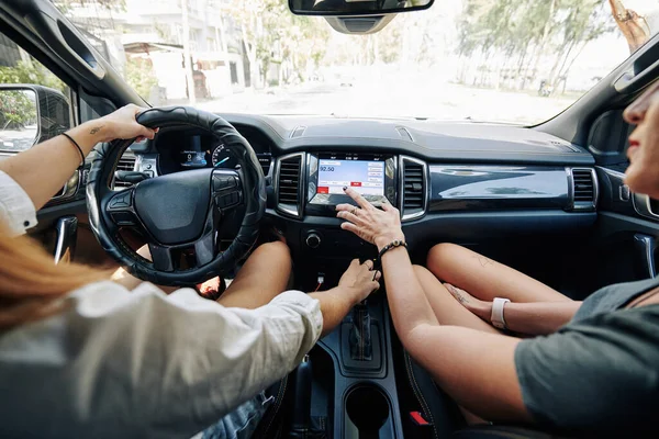 車に乗るときに良い音楽とラジオ局を選択する女性の友人 — ストック写真