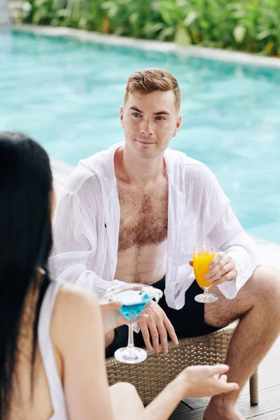 若いカップルがプールパーティーに参加するときにおいしいカクテルを話して飲む — ストック写真