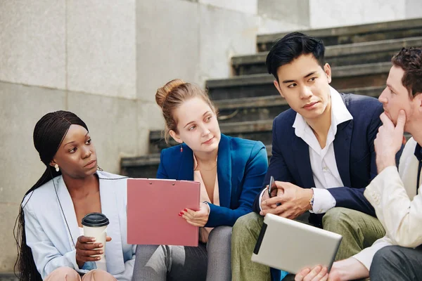 Compañeros Trabajo Multiétnicos Mirando Hombre Negocios Que Habla Cuando Sienta — Foto de Stock