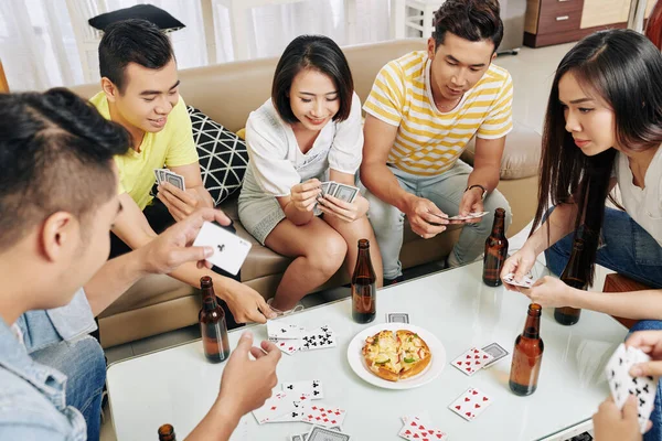 一群快乐的朋友在家里打牌时喝啤酒和吃披萨 — 图库照片