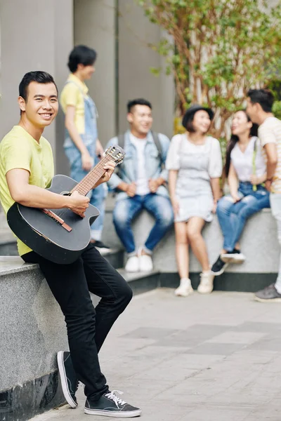 富有创造力的年轻越南学生站在艺术学院的校园里弹奏吉他 — 图库照片