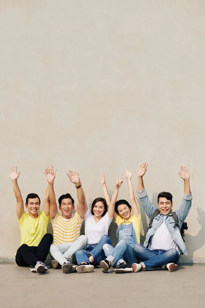 Grupo Jovens Asiáticos Felizes Animados Sentados Parede Levantando Braços — Fotografia de Stock