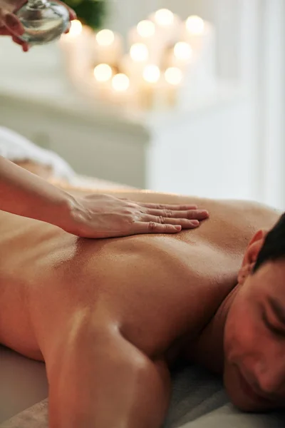 Massagista Derramando Óleo Massagem Parte Trás Cliente Masculino Relaxante Mesa — Fotografia de Stock