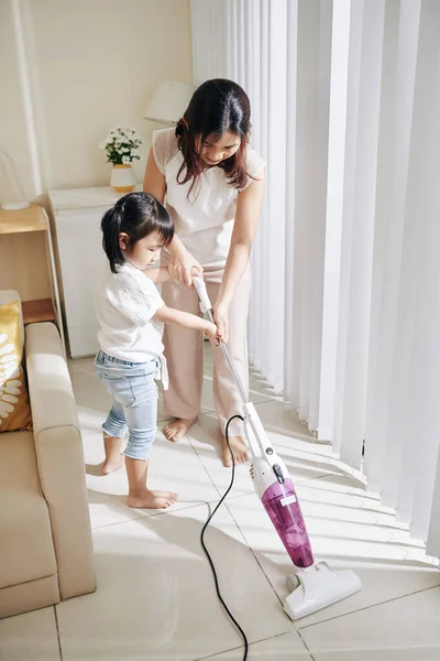 Little Asian Girl Helping Mother Vacuum Cleaning Apartment — Stock Photo, Image