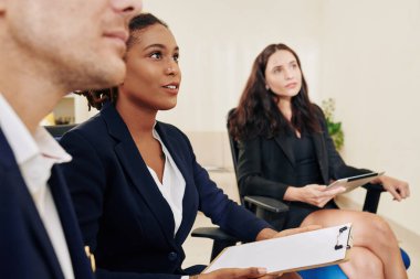 Heyecanlı genç iş kadını toplantıda bir soruya cevap veriyor.