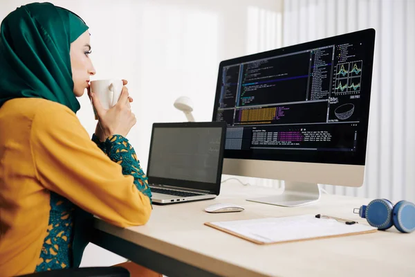 Töprengő Női Muszlim Kódoló Teát Iszik Nézi Programkódot Számítógép Képernyőjén — Stock Fotó
