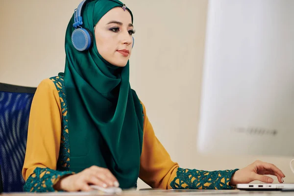 Young Serious Muslim Woman Hijab Listening Music Headphones Working Computer — Stock Photo, Image