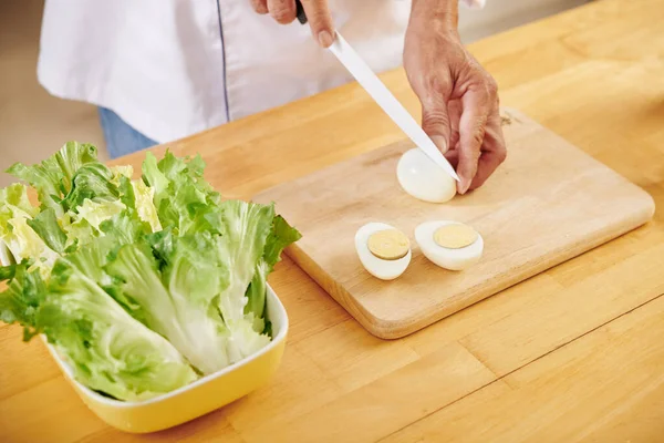 Adam Evde Sezar Salatası Yaparken Haşlanmış Yumurta Kesiyor — Stok fotoğraf