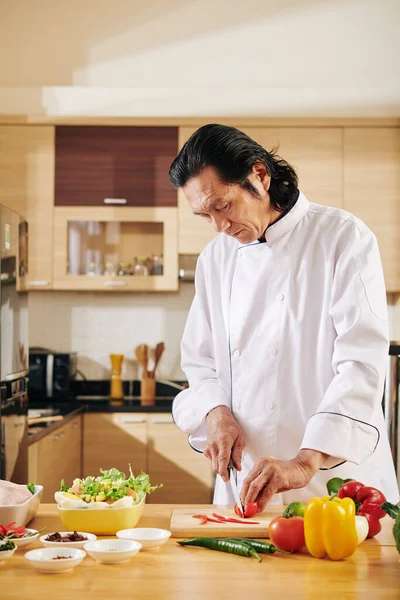 Serious Mature Vietnamese Man Chef Coat Concentrated Cutting Bell Pepper — Stock Photo, Image