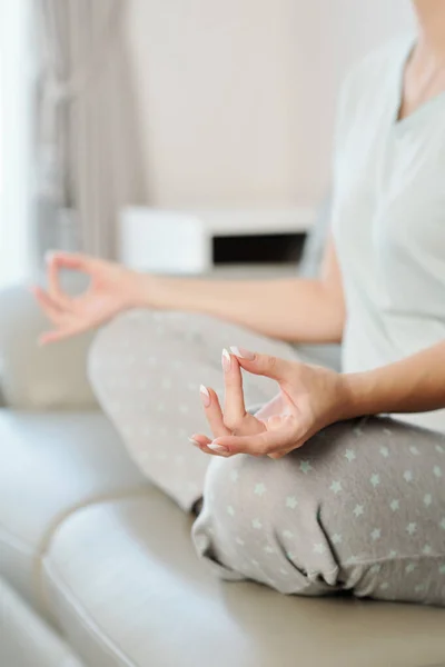 Evdeki Kanepede Meditasyon Yaparken Ele Tutuşan Genç Bir Kadın — Stok fotoğraf