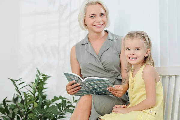 Glada Kvinna Läser Bok För Sin Dotter När Väntar Sjukhuset — Stockfoto