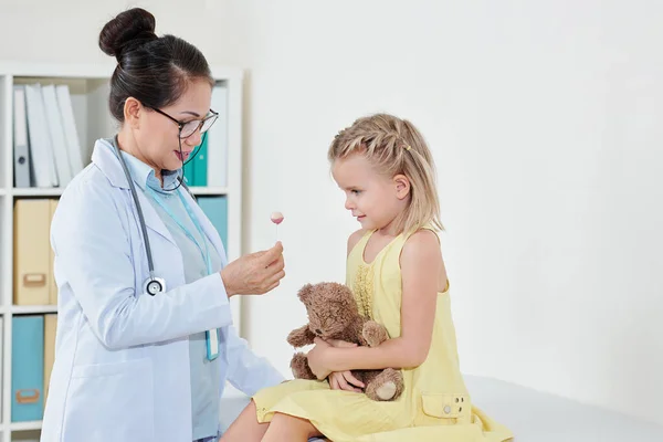 Uśmiechnięty Pediatra Dający Lizaka Małej Dziewczynce Próbującej Złagodzić Strach Przed — Zdjęcie stockowe