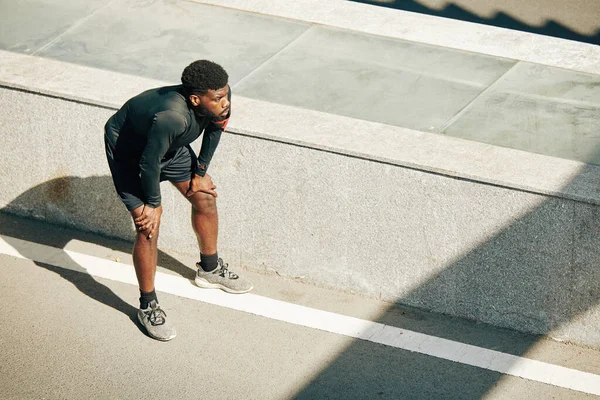 Tired Sportsman Leaning Knees Having Short Rest Jogging Outdoors — Stock Photo, Image