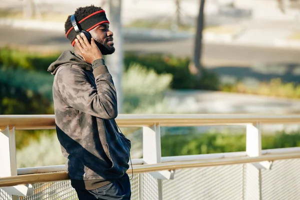 Joven Sonriente Con Auriculares Pie Parque Ciudad Disfrutando Música Favorita —  Fotos de Stock