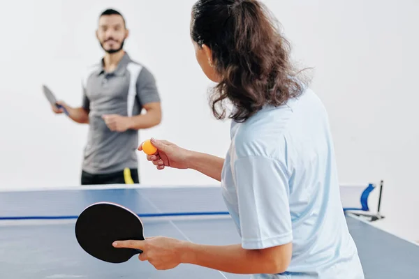 仕事の後に彼女の友人と卓球をプレイするときにピンポンボールを提供女性 — ストック写真