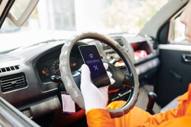 Servis çalışanı akıllı telefondan yeni talepleri kontrol ediyor