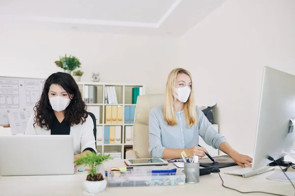 Team Von Grafikerinnen Medizinischen Masken Sitzen Nebeneinander Schreibtisch Wenn Sie — Stockfoto