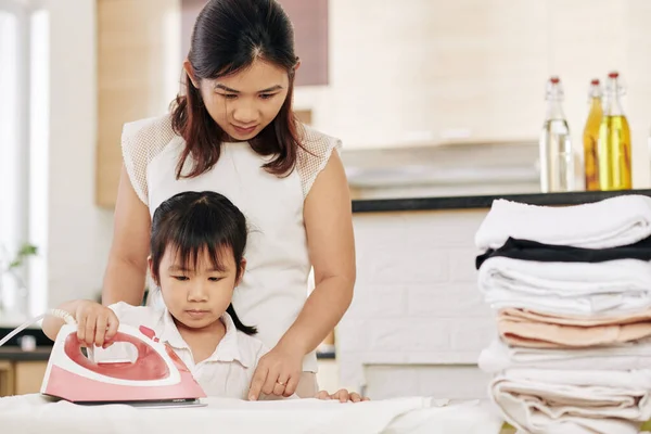 Young Asian Woman Showing Her Little Daughter How Iron Clothes — Stock Photo, Image